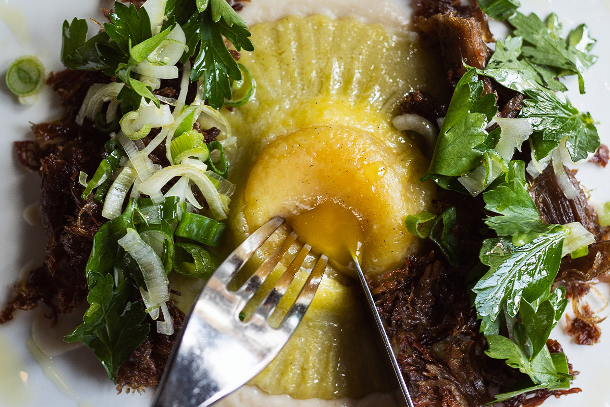 House-made raviolo with duck confit and herb salad